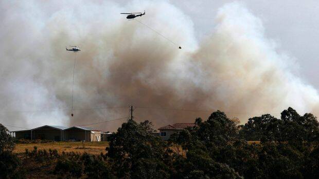 A water bombing helicopter fights the bushfire at Richmond Vale near Cessnock. Photo: AAP