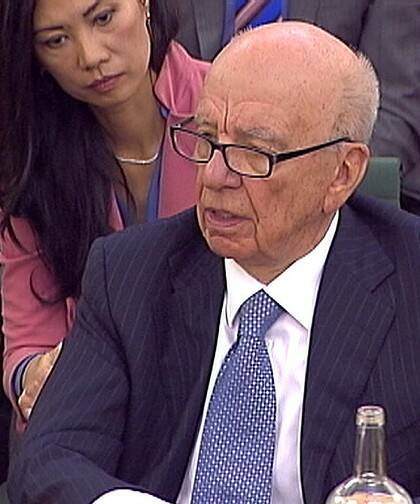 Out of touch ...  Rupert Murdoch answers a question as his wife Wendi Deng looks on.