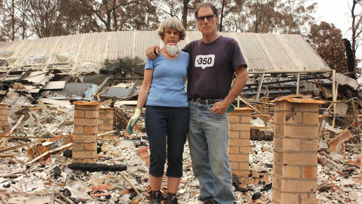 Nick Hopkins and his wife Heike Sutherland in the rubble of their Malua Bay home. Picture: Supplied