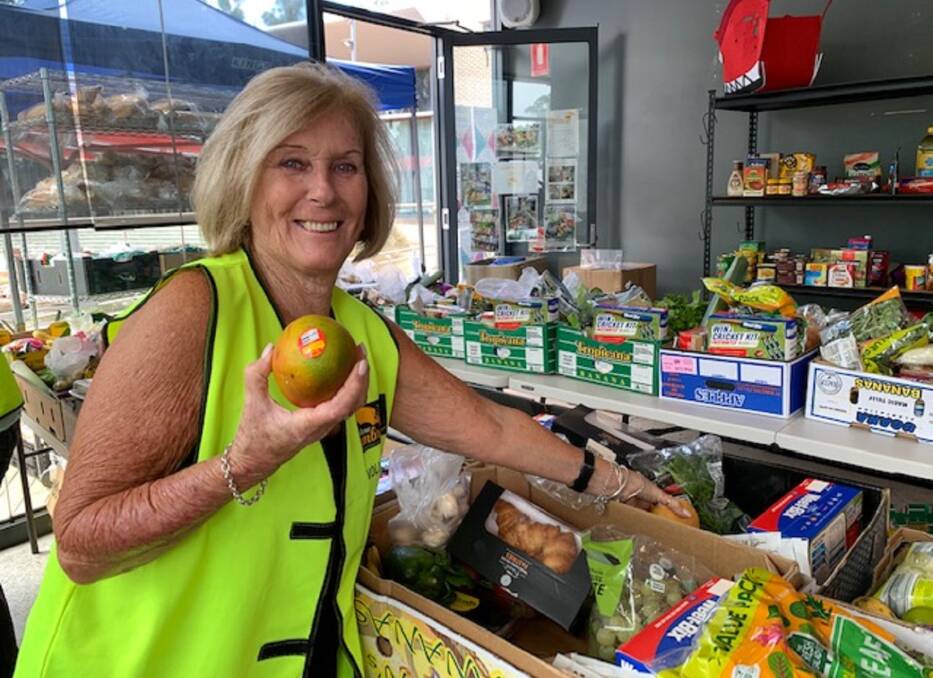 COMMUNITY EFFORT: Big Yellow Umbrella volunteer Christine Hogan helps pack food hampers for the disadvantaged residents who benefit from the program.