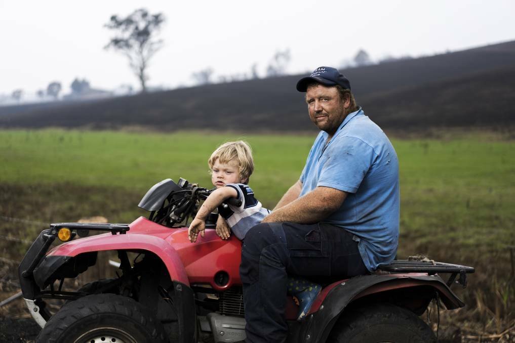  Aaron Salway, with his nephew Harley Salway, 2. Just behind them is the ridge where Aaron's father Robert, and brother Patrick Salway died protecting their property in Wandella. Picture: Dion Georgopoulos
