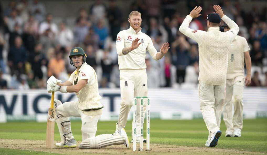 England's Ben Stokes, centre, celebrates with teammates after taking the wicket of Australia's Marnus Labuschagne.