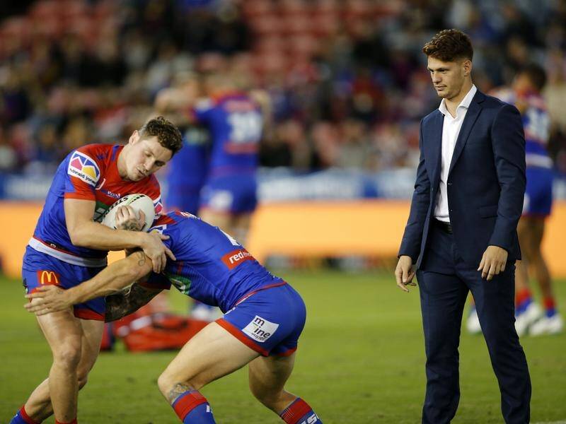 Crocked Kalyn Ponga (r) watched his Knights teammates warm up ahead of their defeat to the Broncos.