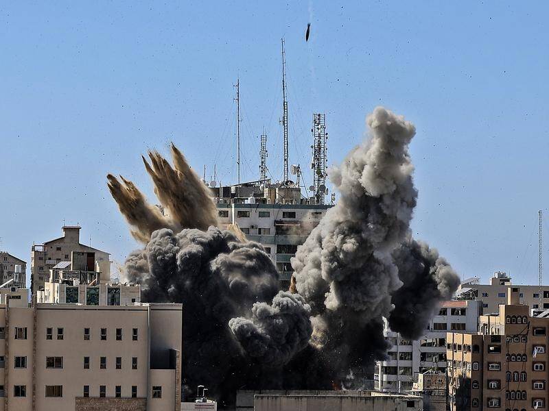 A bomb hits a building housing international media outlets in Gaza City.